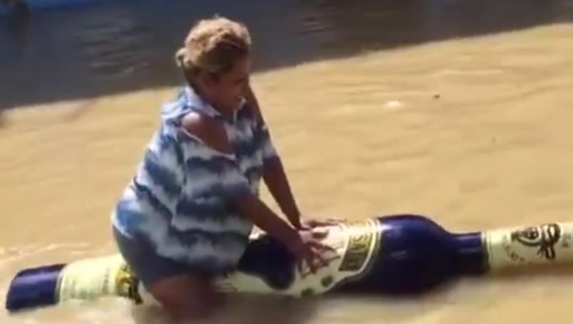 Mujer atraviesa inundación en Tabasco con botella de tequila inflable || VIDEO