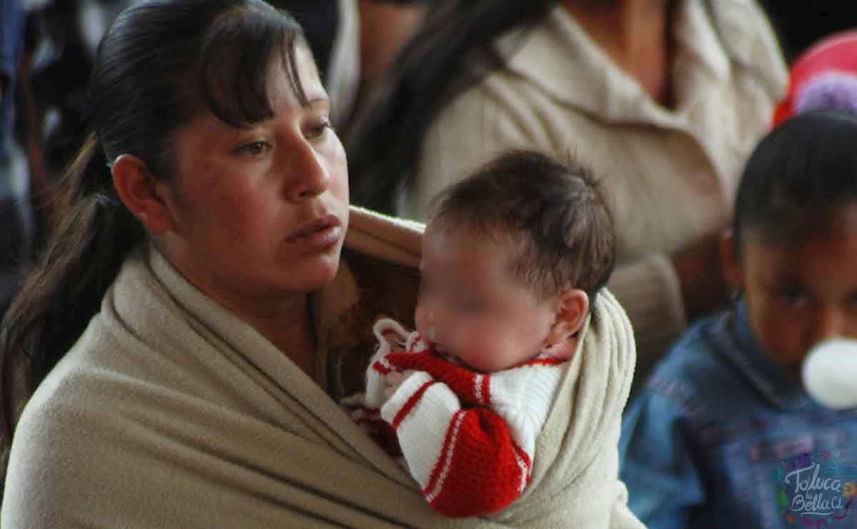 Mujer con bebé en brazos esperando a recibir su apoyo económico del gobierno del Edomex