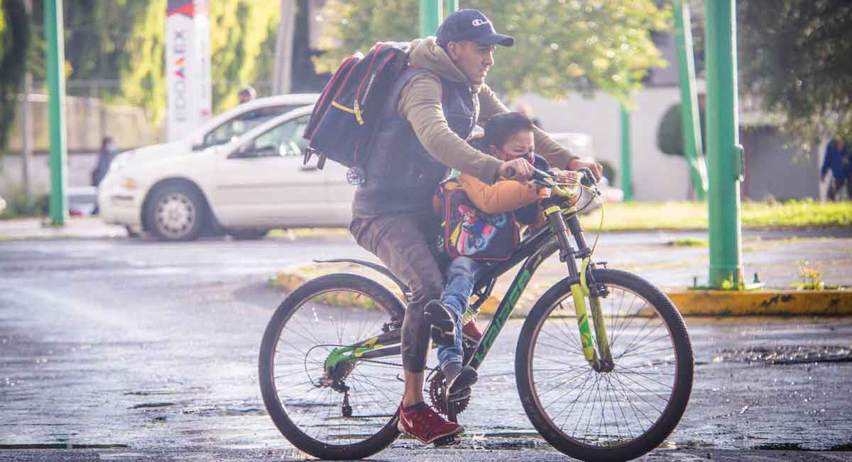 padre lleva su hijo en bicicleta a los ultimso días de clase antes de las vacaciones de verano sep 2022