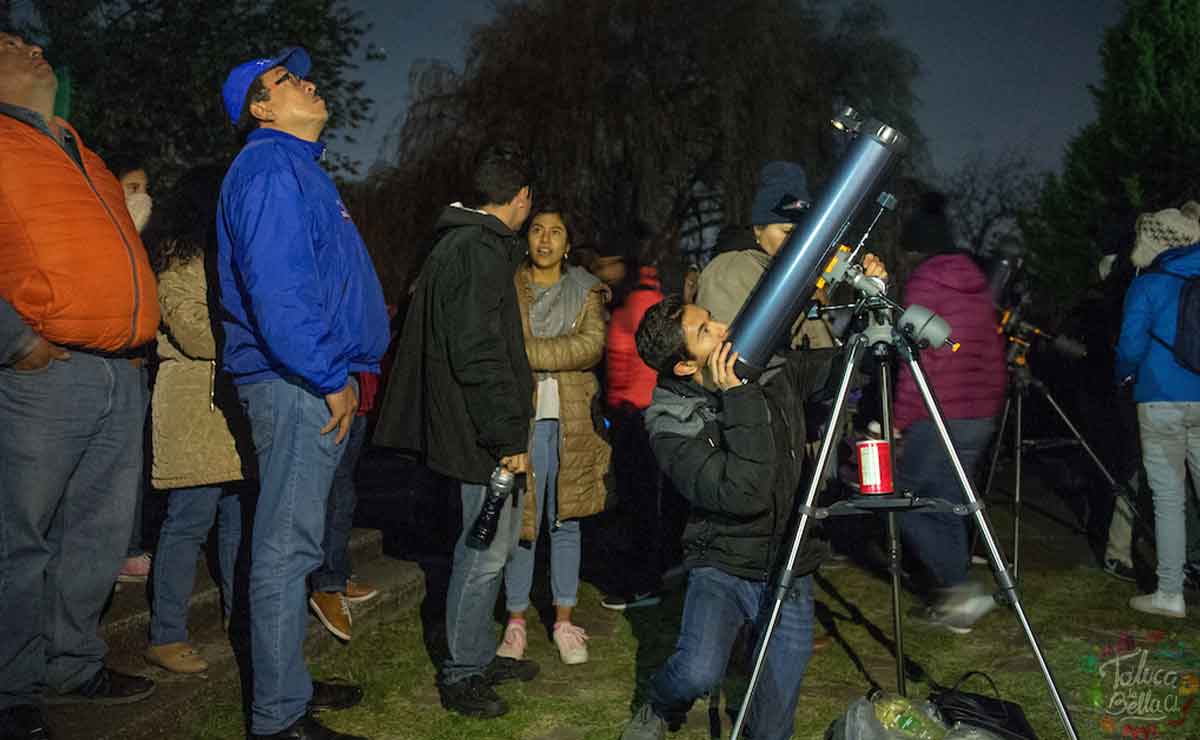 Personas reunidas contemplando los planetas en Toluca